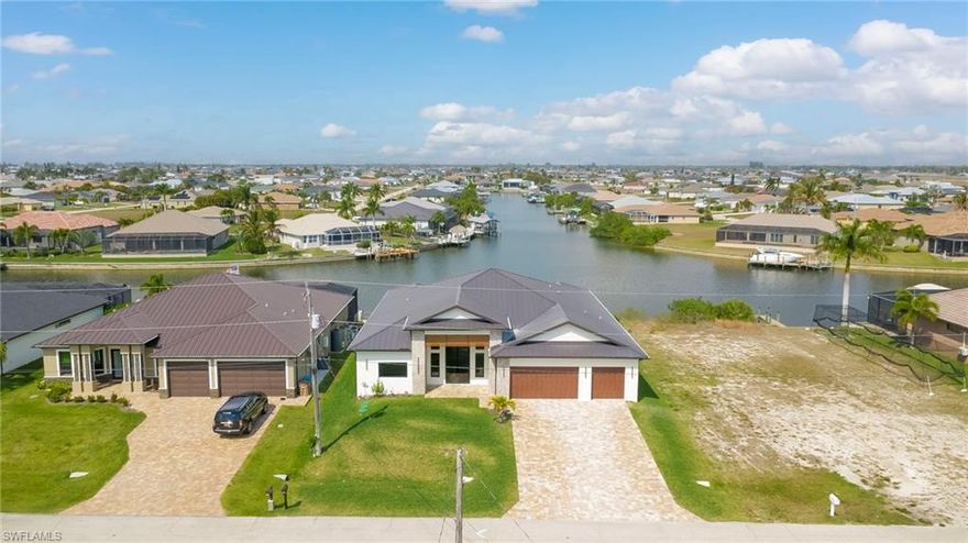 Experience the ultimate Florida lifestyle in this stunning new construction, custom-built waterfront home located in the rapidly growing Northwest Cape Coral Tropicana area. Offering 3 bedrooms plus a den, 3 full bathrooms, and a spacious 3-car garage, this impressive 2,869-square-foot residence was thoughtfully designed to combine modern luxury with everyday comfort and efficiency.
Built with energy-efficient ICF (Insulated Concrete Form) reinforced concrete construction and topped with a sleek metal roof with foam insulation, the home delivers exceptional strength, durability, and efficiency. A high-efficiency Carrier air conditioning system, thermal insulated garage doors, LED lighting throughout, and a tankless water heater further enhance performance.

Inside, soaring 14-foot ceilings and elegant tile flooring throughout create a bright, open atmosphere. Custom architectural ceiling details and beautiful wood plank ceiling accents add warmth and sophistication. Impact-resistant ESW Prestige windows and doors provide superior protection and insulation while filling the home with natural light. Dramatic 10-foot sliding glass doors seamlessly connect indoor and outdoor living while showcasing waterfront views.

The kitchen is a showpiece, featuring custom Italian cabinetry, premium Sub-Zero and Wolf appliances, and stunning quartzite countertops with a waterfall island. A large hidden walk-in pantry offers both convenience and style. The space is complemented by decorative lighting, high-end plumbing fixtures from Kohler, Delta, and Kingston, and solid wood interior doors throughout the home.

The luxurious primary suite provides a peaceful retreat with custom-built closet systems and a spa-inspired bathroom featuring an oversized shower, soaking tub, and dual floating vanities. The primary closet also offers convenient access to the spacious laundry room.

Step outside to an exceptional waterfront outdoor living space overlooking a breathtaking 230-foot-wide intersecting Gulf-access canal. The expansive lanai features elegant white marble flooring and wood plank ceilings, creating the perfect setting for relaxing or entertaining. The outdoor kitchen includes premium appliances including a Napoleon grill, gas burners, and a quartzite countertop bar. A custom-designed heated saltwater pool with integrated spa overlooks the tranquil water views.

Additional features include a deep well with whole-house reverse osmosis water purification, a 500-gallon water tank, 400-amp electrical service, epoxy-coated garage flooring, smart-home technology, Wi-Fi irrigation controls, and security cameras.

Ideally located near the highly anticipated Seven Islands waterfront development and boardwalk, this exceptional home offers direct Gulf-access boating, modern luxury finishes, and cutting-edge construction in one of Cape Coral’s fastest-growing neighborhoods.

Schedule your private showing today and experience this remarkable waterfront home.