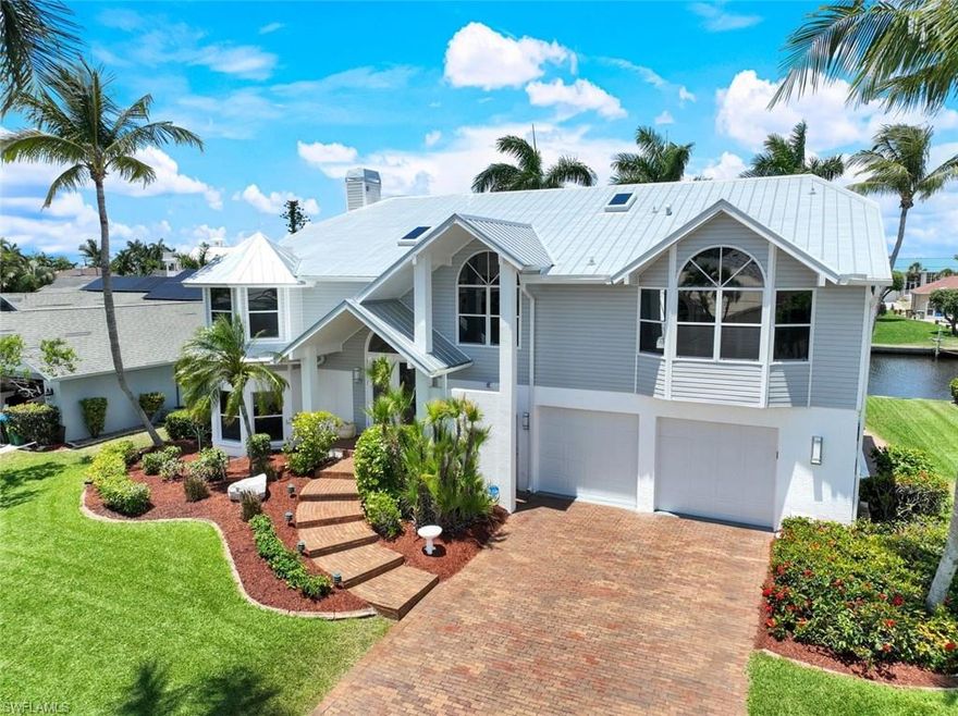 Exquisite Custom Key West Home with Deep Water Direct Access! Located next to the Tarpon Point area in SW Cape Coral, Unit 64. Discover your dream home in one of Cape Coral's most sought-after locations! This stunning custom-designed Key West residence boasts deep water direct access, perfect for accommodating larger boats. Key Features include panoramic views from the spacious upstairs living area, featuring impressive high cathedral ceilings and expansive windows that fill the space with natural light.The heart of the home showcases a beautiful updated Gourmet kitchen, equipped with a new commercial-sized refrigerator and modern appliances, ideal for entertaining.A real coral fireplace serves as a focal point in the living area, creating a warm and inviting atmosphere for gatherings with family and friends.The expansive primary bedroom offers stunning views of the pool and canal through large windows, providing a serene retreat. Step into a newly upgraded bathroom featuring a spacious walk-in shower with a top-of-the-line rain showerhead, a separate soaking tub, modern countertops, cabinets, and stylish lighting. The main living floor also includes a dedicated office/den space, perfect for remote work or study, along with a newly renovated powder room for guests. The outdoors is an Outside Oasis, overlooking  the wrap-around dock that features electric capabilities and an 8,000 lb boat lift, allowing for seamless boating experiences. There’s also substantial room for expansion, ensuring that your aquatic adventures can be maximized. The oversized pool, spa, and newer outdoor kitchen, along with a spacious lanai, create an amazing environment for entertaining guests and enjoying sunny Florida days. Downstairs, you'll find a billiard room, a full pool bathroom, and two guest bedrooms with a Jack and Jill bathroom, making it an ideal space for hosting family and friends.

This home is not just a residence but an entertainment paradise, making it one of the best homes for hosting in Cape Coral. Experience the ultimate waterfront lifestyle with direct access to the beautiful waterways and Gulf of America.
*Assumable Flood Insurance Policy, 9’ft Elevation.