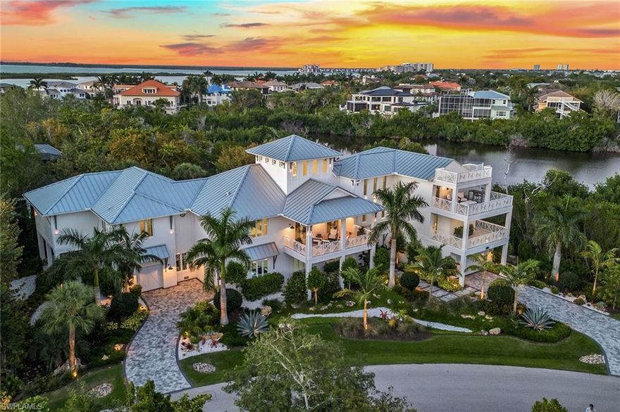 Presenting possibly the most impressive custom-built architectural masterpiece on one of the largest lots in prestigious Hideaway Beach with an outstanding location close to the beach and luxurious community amenities. Standing proudly at nearly 5,000 square feet of air-conditioned living space and more than 11,000 square feet under roof on a very private homesite encompassing almost three-quarters of an acre, this home features five bedrooms plus an office, five full baths, and one half bath. The first floor includes two air-conditioned garages with epoxy flooring and dual 6,000-pound car lifts, accommodating up to 11 cars. From the moment you approach, the home’s grandeur is undeniable, with two paver driveways, elegant landscape lighting, a durable metal roof, and impact turtle glass complementing its stately presence. The interior is a testament to luxury and comfort, boasting high-end designer furnishings, porcelain wood-like tile floors throughout, exquisite lighting, and finished with bleached oak and white shiplap, creating an ambiance of refined coastal elegance. Ascend via the three-stop elevator or take the oak staircase with LED-lit steps to unveil a gourmet kitchen featuring bespoke white cabinetry, waterfall-edge quartzite countertop, two large center islands, a butler’s pantry, and top-tier Wolf and Sub-Zero appliances. The adjacent living room, with its 28-foot cathedral ceiling, one-of-a-kind floating beam design, and oak textured media wall with fireplace, opens to an expansive lanai offering views of the 43-foot pool with a spa and sun shelf. This outdoor haven includes an outdoor kitchen with a built-in gas grill and beverage cooler, gas fireplace, and covered living spaces that epitomize luxury living. The owner’s suite is a private retreat with an LED-lit beam ceiling, a spa-like en-suite, and a private balcony overlooking the heated pool and waterways. The three guest bedrooms on this floor each have en-suite baths and one featuring four built-in bunk beds, accommodating guests in style. The third floor houses a fourth guest bedroom, a full bath, and a versatile office/media room with a wet bar and access to the fourth-floor observation deck showcasing stunning beach, water, and sunset views. Additional features such as a bar in the dining area, Control4 automation system, intricate ceilings, and a whole-home generator underscore the no-expense-spared approach to this home. Residents of Hideaway Beach enjoy ample amenities including access to over two miles of pristine beach, an elegant clubhouse with a swimming pool and both casual and fine dining overlooking the beach, a beautiful nine-hole executive golf course, tennis and pickleball courts, and a spectacular brand-new sports center in progress. The community also offers an extensive activity and event calendar, and the security of gated, patrolled grounds. This one-of-a-kind property offers a rare opportunity to own a very special piece of Marco Island paradise!