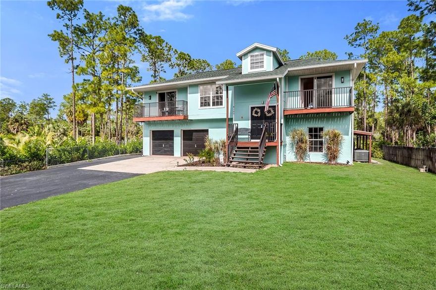 On a private 1.14-acre homesite in Golden Gate Estates and in a no-flood zone, this expansive two-story residence offers space, versatility and outdoor living rarely found at this scale. The thoughtfully designed floor plan includes five bedrooms plus a den, three full baths and a two-car garage, with recent improvements including a new roof in 2026 and a 2018 HVAC system. A long gated driveway leads to the fully fenced property, providing privacy and room to spread out, while the oversized backyard features mature fruit trees, a garden area and even a chicken coop for those seeking an estate-style lifestyle. Outdoor living is a highlight, centered around a large fenced pool deck with a heated pool and generous sun shelf, ideal for relaxing or entertaining. Covered outdoor living areas include ceiling fans and ample space for lounging and dining, while an upper-level balcony adds another peaceful vantage point overlooking the grounds. Inside, diagonal tile flooring and crown molding anchor the lower level, where three guest bedrooms are conveniently on the first floor and share a nearby full bath with a shower-tub combination. The main living level showcases wood-look tile flooring, vaulted ceilings, and an open layout connecting the kitchen, dining and living areas. The kitchen is bright and functional with white cabinetry, a tile backsplash, a center island with breakfast bar seating and newer stainless steel appliances, including a double-oven range, microwave, refrigerator, freezer and dishwasher. The dining area flows seamlessly into the living room and opens through glass sliders to a large outdoor deck, creating effortless indoor-outdoor living. The owner’s suite offers a private retreat with direct lanai access through glass sliders, a walk-in closet with shelving and an en-suite bath featuring a dual-sink vanity, full-width mirror and a walk-in shower with glass enclosure, with convenient access from the main deck as well.  An additional guest bedroom also enjoys access to the main deck and sits adjacent to a full bath, while the den offers flexibility as a potential sixth bedroom, home office, or study and includes its lanai access. Completing the home is a well-appointed laundry room with wall trim, granite countertops, and Samsung washer and dryer. With acreage, privacy, modern updates and versatile living spaces, this property delivers a rare opportunity to enjoy estate living with comfort and functionality.