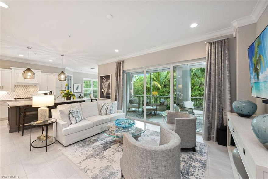 Experience the ultimate luxury resort lifestyle in this meticulously maintained second-floor end unit condominium at Signature Club in Lely Resort. This rarely available and highly desirable St. Andrews model, built by Stock Development in 2019, offers 2,738 square feet of luxurious living space with four bedrooms, three full baths, one-half bath and a private elevator. Surrounded by lush magnolia and palm trees, this quality residence is filled with natural light and offers a private location. Step inside to discover an elegant and pristine interior with white plantation shutters, custom draperies, crown molding and recessed lighting throughout, with tile flooring in the main living areas. The grand foyer welcomes you with an impressive chandelier, tray ceiling and 19-foot ceiling height. The modern kitchen is a chef’s dream with white cabinets, a mosaic tile backsplash, quartz countertops, a kitchen sink water filter spigot, natural gas cooking, wall oven, pantry and stainless appliances. The kitchen’s large island as well as the formal dining area, highlighted by a dramatic crystal halo light, are ideal for entertaining. The spacious living room, with glass sliders opening to the lanai, offers a seamless blend of indoor and outdoor living. The lanai, featuring a screen enclosure and a large outdoor living space, provides views of beautiful tropical palm trees. The owner’s suite is a private retreat with lanai access, garden views, a tray ceiling, two walk-in closets with custom shelving, and an en-suite bath with a dual sink vanity, full-width mirror, walk-in shower with a frameless glass enclosure and a separate soaking tub. The guest bedrooms are equally impressive. One bedroom offers access to a private balcony and a large en-suite bath with a white vanity, quartz countertops and a walk-in shower tiled floor to ceiling. Another guest bedroom also has an en-suite bath with a shower-tub combo. The third guest bedroom can double as a study/den with a custom glass door. The laundry room provides ample storage with white cabinets, a utility sink, a built-in desk, and newer washer and dryer. The exterior of this home features impact-resistant windows, doors/sliders, and storm-smart remote-controlled shutters enclosing the lanai. The two-car garage offers epoxy flooring. Modern conveniences include available CAT 6 wiring, ADT security and a reverse osmosis eco-water system. Residents of the Signature Club have access to the exclusive Players Club and Spa amenities, including tennis, pickleball, bocce, a business center, a clubhouse with three pools, a hot tub, a restaurant, a tiki bar, a fitness center, full-service salon, social events, and holiday brunches and dinners. Lely Resort offers bike/recreation paths, two public golf courses Mustang and Flamingo, and the private Classics Golf & Country Club, all just minutes away. Great location, close to all Naples and Marco Island attractions. The exquisite furnishings are negotiable.