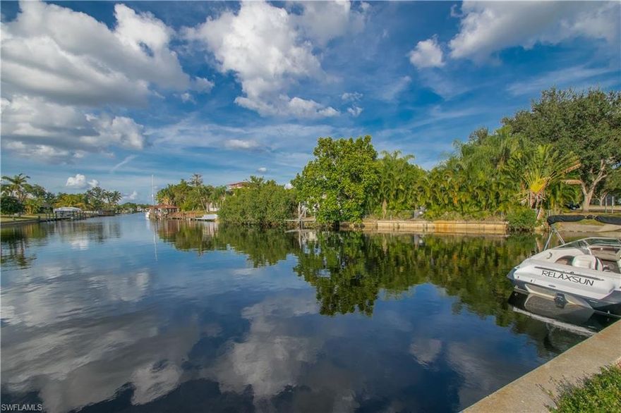 Gulf Access Pool Home w/ Adjacent LOT & Workshop/Garage Included in Sale! 3 Bedroom, 2.5 Bath, 1-Car Garage (w/ built-in shelving) PLUS a 24'x24' free standing Garage/Workshop equipped w/ 120/240v electric, water, & A/C. The lot the home sits on is 120' deep x 70' wide and the adjacent lot w/ the Garage/Workshop is 120' deep x 75' wide. There is also a wooden dock on the lot that has a (approx) 5000 lb electric boat lift that can be modified, plus the boat dock pilings are still behind the home if Buyer desires to build a new dock there. These two lots can be separated into two parcels if Buyer ever wants to build on the lot. Cute-as-a-button home w/ screened lanais on the front & the back, clear polycarbonate window coverings for hurricane protection, lawn sprinkler system, tile in main living areas and NEW carpet in Bathrooms and Master Bedroom. A/C on the home was replaced around 2011. One Guest Room is to the rear of the home features built-in shelving & sliders to the pool lanai- would be perfect as an Entertainment/Family Room. The Extended Screened Pool Lanai has just been resurfaced, NEW pump installed and the screen enclosure was replaced last year.