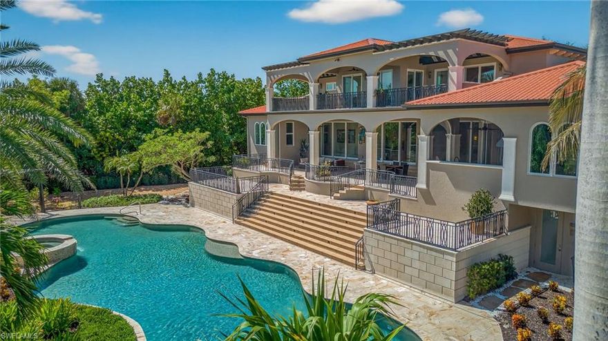 A truly extraordinary tropical oasis, this stunning estate is set just steps from Sanibel’s pristine beaches on a private cul-de-sac surrounded by lush, manicured landscaping. The approximately 1-acre setting feels like a secluded resort, anchored by Sanibel’s largest private residential pool—an 82-ft free form masterpiece framed by an elevated waterfall spa, travertine pavers, custom pergola, tropical grounds with walking paths lined by swaying coconut palms. Whether you’re swimming laps at sunrise or unwinding beneath the stars, every inch of the outdoor space is designed to celebrate the island lifestyle. In perfect harmony with this breathtaking setting, the 5,000 +/- SF home is a modern European-inspired fortress—crafted from solid concrete block, topped with durable Permatile roofing, and built to endure. Impact-rated glass doors and windows invite natural light while offering storm protection. A whole-house Kohler generator, elevated HVAC, Halo water purification system, and private elevator ensure comfort, safety, and peace of mind year-round. Inside, the design is both refined and inviting. A floating white oak staircase under a Murano glass chandelier makes a bold statement, while an open-concept layout flows effortlessly from the living room’s gas fireplace, that anchors the space with warmth and style, to the chef’s kitchen which is a showstopper, outfitted with Wolf & Sub-Zero appliances, walk-in pantry, custom cabinetry, wine fridge, and a beverage center—perfect for entertaining. The 1,200 SF upstairs primary suite offers a tranquil retreat with a private lanai, dual walk-in closets, and a marble-accented spa bath. The main level features 3 ensuite bedrooms including a private in-law suite with a morning kitchen. Touches such as a private office with custom shelving, Sonos system, dual laundry rooms, tankless water heaters, and pet wash stations make this resort style home truly one-of-a-kind.