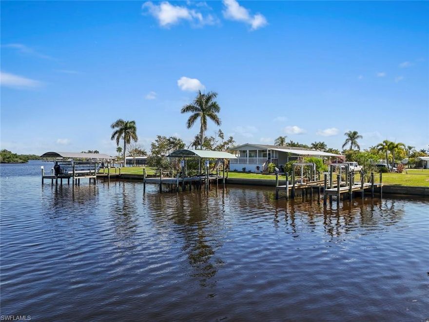Enjoy true Southwest Florida boating lifestyle with direct Gulf access, watching manatees dance in the sunsets right from your backyard. This elevated 2023-built waterfront home in Orange Harbor offers the rare combination of newer construction, modern finishes, and immediate access to open water. Inside, you’ll find 1,336 sq ft of light-filled living space with a clean, coastal design, luxury vinyl plank flooring throughout, and an open-concept layout ideal for everyday living and entertaining. The kitchen is a standout, featuring quartz countertops, stainless steel appliances, custom cabinetry, and a large center island, all flowing seamlessly into the main living and dining areas.

A flexible den with French doors provides the perfect space for a home office, guest room, or hobby area. The primary suite offers generous space with dual walk-through closets and a well-appointed bath with a walk-in shower. A comfortable guest bedroom, full bath, and laundry room with additional cabinetry and utility sink add to the home’s functionality.

Step outside to your covered waterfront porch overlooking the Orange River, where you can relax and take in peaceful water views. Just beyond, your private dock is fully equipped with composite decking, water, electric, and a 7,500 lb. boat lift, making it effortless to get out on the water.
Located in the gated, pet-friendly Orange Harbor 55+ community, residents enjoy a vibrant lifestyle with amenities including a heated community pool, clubhouse, two boat ramps, fishing pier, pickleball, bocce, and shuffleboard. The low monthly fee of $406 includes water, sewer, lawn care, trash, and fiber optic internet.
Conveniently close to downtown Fort Myers, Manatee Park, shopping, and dining, this home offers a unique opportunity to enjoy direct-access waterfront living with modern comfort in an active community setting.