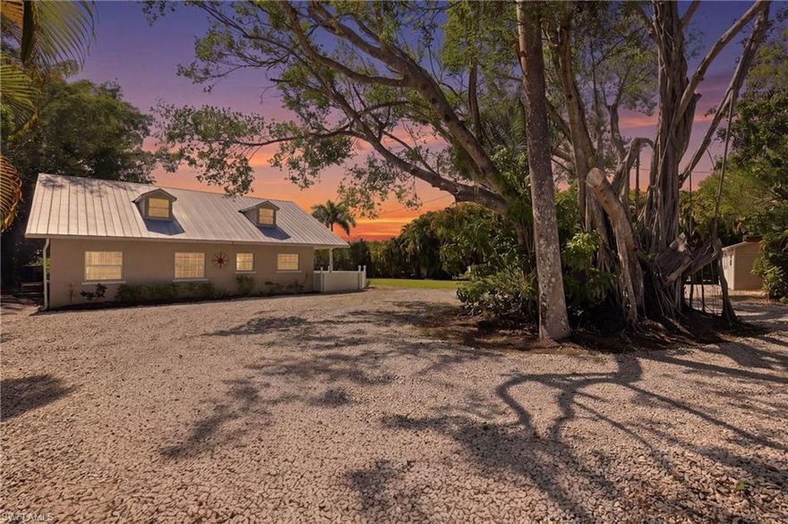 One or more photo(s) has been virtually staged, AI generated or rendered.  Waterfront retreat with private boat dock! Tucked beneath a canopy of mature banyan and oak trees, this waterfront property offers genuine Florida living with direct water access, a covered boat dock with lift, and lush tropical surroundings. Set on a generous lot with exceptional privacy, this three bedroom, two and a half bath home presents an opportunity for buyers seeking waterfront access. The home features an open concept layout with vaulted ceilings and abundant windows and skylights flooding the great room with natural light. The kitchen offers updated cabinetry, countertops, and stainless steel appliances with views of the surrounding landscape. The primary suite includes an en suite bath, while two additional bedrooms provide comfortable living space. A second full bath, powder room, and laundry room complete the interior. The generous covered patio overlooks the backyard and is ideal for outdoor enjoyment. A private covered boat dock provides direct waterway access, perfectly positioned for boating and water recreation. With mature tropical landscaping, a metal roof, and a circular drive, the property offers exceptional privacy and character. Located in North Fort Myers near the Caloosahatchee River, you are minutes away from the Forr Myers International Airport, making travel convenient. Nearby amenities include Gulf Coast Town Center with exceptional shopping and dining, the Shell Factory and Nature Park, and easy access to downtown Fort Myers by land or water. Judd Park is within walking distance and features dog parks, tennis courts, a boat ramp, and a playground. Homes with this much land on a canal don't come around often. Waterfront living awaits. Schedule your viewing today.  One or more photo(s) has been virtually staged, AI generated or rendered.