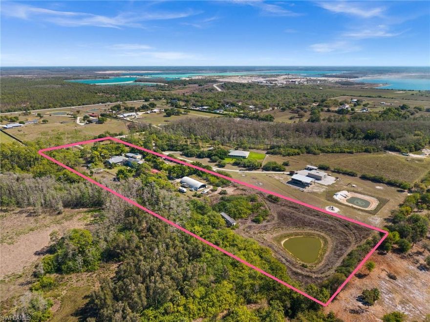 Welcome to a truly rare 10-acre estate - zoned Agricultural (AG-2) with Single Family Residential and Equestrian use - offering an unparalleled combination of privacy, space, and versatility just 5 miles from RSW International Airport.
Through the private gated entrance on North Mallard Lane - a paved private road where your property line extends to the street's centerline - you will find a fully developed compound of multiple buildings, equestrian facilities, and open pasture - no wetlands and no flood zone (Zone X). Approximately 5 acres are additionally buildable, offering meaningful room to expand or develop further.
The main residence is a 2-story Colonial-style home built in 2008, totaling 5,385 sq ft of living area with 9 bedrooms and 6 bathrooms including adjacent buildings. The front structure is wood-framed; all other buildings on the property are constructed of AAC block - one of the most energy-efficient building materials available. Current monthly utility costs only run approximately $300 for the entire 5,385 sq ft. The home includes a wood-burning fireplace, screened covered porch, multiple open patios, finished garage, and finished upper story, all connected through the interior. An outdoor pool and separate guest quarters provide flexible accommodation for extended family, caretakers, or rental income.
Nestled above the barn is a charming wood house imported from Germany - a self-contained space with an additional bedroom and bath, also built with AAC block construction.
The EQUESTRIAN infrastructure is built for serious horse owners. A 3,780 sq ft metal barn and a 2,160 sq ft finished wood barn/stable accommodate up to 10 horses, complemented by a dedicated riding arena and round pen for training. A 760 sq ft pole shed completes the agricultural support structures.
The former airplane hangar - a Quonset-style metal structure measuring 50 x 100 ft (5,000 sq ft) - functions as an oversized workshop or equipment bay, ideal for farm machinery, recreational vehicles, or boats.
Two natural ponds enhance the landscape: one visible from the rear of the main residence, a second in the back pasture. Fruit trees frame the property's natural character. There are no wetlands on the property.
City water is available at the street - an elective connection the new owner can establish. Located within the outer growth ring of Lee County, with I-75, schools, retail, restaurants, and employment all within a short drive, this estate delivers rural tranquility without sacrificing genuine accessibility. Whether your vision is a private family compound, an equestrian retreat, a working farm, or an entertaining venue - the land and infrastructure are already in place.