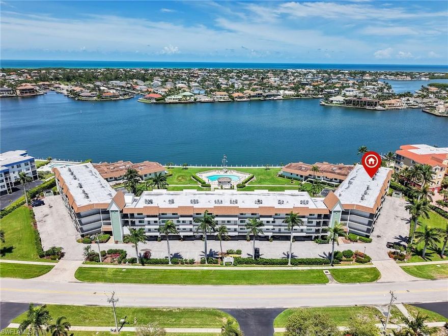Experience the pinnacle of waterfront living in this turnkey furnished second-floor residence overlooking the sparkling waters of Smokehouse Bay, ideally situated in the premier boating community of Smokehouse Harbour. This light-filled 2-bedroom, 2-bath condo captures stunning southwestern bay views from the living room, primary bedroom & lanai. A welcoming entry foyer leads into the spacious great room, where the bay views take center stage. The thoughtfully designed split-bedroom floor plan offers privacy for both owners and guests, while tile flooring runs throughout the inside of the residence and in the screened lanai - no carpet anywhere! The kitchen is appointed with neutral Corian countertops and a new Whirlpool refrigerator (2026). The primary suite is a private retreat featuring a walk-in closet and an extended vanity with extra counter space and has a tub & shower. The guest suite includes an en-suite bath with a shower and sliding glass doors. Enjoy the convenience of an in-unit full-size washer and dryer. Recent mechanical updates that provide both comfort and peace of mind, including a new A/C system (2025), new water heater (2026), new electric hurricane shutter on the screened lanai (2026), and impact windows. New building roofs are also currently being installed. Residents enjoy a heated pool, fishing pier, and community dock, with boat slips available via a short waitlist. This condo also includes a deeded covered parking space in a prime location directly in front of the building, plus an extra storage closet on the ground floor. Located just down the street from the waterfront dining and boutique shopping of the Esplanade Shoppes, and only minutes from Tigertail Beach, Winn-Dixie, Town Center Mall, and quick access to US 41, this residence offers the ultimate Marco Island lifestyle!