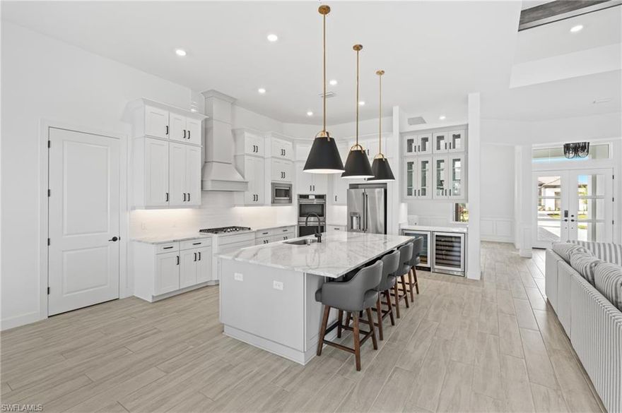 $200,000 PRICE REDUCTION — RARE LAKEFRONT ON PREMIUM LOT IN ESPLANADE BY THE ISLANDS
Situated on a highly sought-after $400,000 premium lot with long, unobstructed lake views and no future development across the water, this 4,500+ sq ft pool home offers exceptional privacy and a setting rarely available in the community. The upgraded elevation, extended paver driveway, and full hurricane-impact windows and doors add both curb appeal and peace of mind.
Inside, the home features custom finishes throughout, including tray ceilings, wood beam accents, wainscoting, wood-look tile flooring, a fireplace, built-in media wall, and Sonos surround sound. The chef’s kitchen is designed for both everyday living and entertaining, complete with a large island, gas cooktop, double ovens, dual wine coolers, glass-front bar, and soft-close cabinetry.
The first-floor primary suite overlooks the lake and includes dual walk-in closets and a spacious bath with dual vanities and an oversized walk-in shower. Each guest bedroom offers an en-suite bath and walk-in closet. Upstairs, a bonus room with wet bar, full bath, and additional guest suite provides flexible space for entertaining or extended stays.
Outdoor living is enhanced by a gas-heated saltwater pool and spa, panoramic screens, extended covered lanai, outdoor kitchen, and pool bath—all overlooking the serene lake.
Esplanade by the Islands offers resort-style amenities and is conveniently located near Naples, Marco Island, and Gulf beaches. Low HOA fees and no flood zone. A rare opportunity combining location, upgrades, and lifestyle.