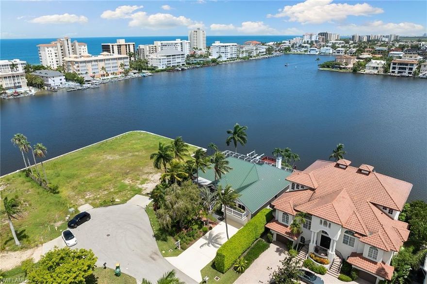 Discover this incredible waterfront property with uninterrupted, expansive views of Vanderbilt Bay. Watch the dolphins and manatees swim in this meticulously maintained, elevated home situated at the end of a tranquil cul-de-sac and just a short a stroll to the beach. The home occupies a generous 0.24-acre lot with an oversized 100 feet of breathtaking water frontage and a spacious and private boat dock equipped with an approximately 10,000-pound lift, perfect for boating enthusiasts to access the Gulf of Mexico. The residence includes four bedrooms plus a den, four full baths, and a two-car garage, encompassing a total of  4,006 square feet. Custom features grace every corner of the home, which is set amidst professionally designed tropical landscaping. Relax by the bayfront pool, unwind on the screened lanai, and savor stunning sunsets from the expansive waterfront dock. Located just minutes from Vanderbilt Beach, The Ritz-Carlton, and the exclusive shopping and restaurants of Mercato and only a short drive to Downtown Naples’ famous 5th Avenue South.