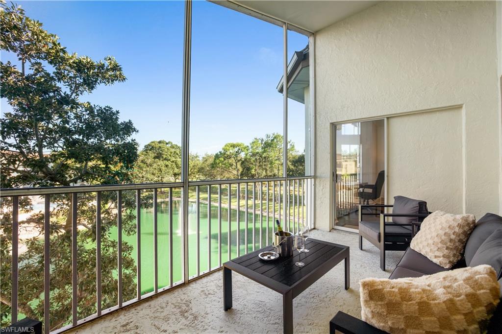 Screened lanai with modern furniture overlooking a tranquil pond and lush landscaping in The Vineyards community, ideal for relaxation and entertaining.