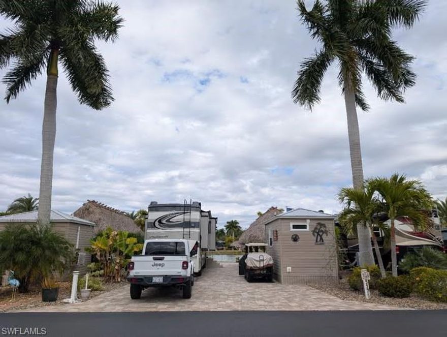 Just imagine living on this north facing Class A fully paved lake lot with a clear view of the water which has a running fountain.  You can experience both sunrises and sunsets right here from your patio.  This 40 x 90‘ lot just had a complete replacement of a Pavers in 2021. The view as well as wonderful birdwatching can be had throughout the day.  Mature landscaping with irrigation keeps your generous vegetation growing season after season.  Relax under your 10 x 34’ Tiki hut that was rethatched in 2024 and is complete with ceiling fans, electrical  lighting, a smart TV.  L-shaped outdoor kitchen is treated wood with teak cabinet doors and drawers, and has storage underneath, granite countertop, large quartz sink with running hot and cold water, undercounter refrigerator.  Also includes 4 bar stools, wicker storage cabinet, countertop oven and hot plate.   Included on the lot is a 8’ x 15’ Amazon shed, finished in 2023, has ceiling pot lights and fan, mini split heat/air (one year old), water softener, complete bathroom including toilet, shower, and vanity sink.  Queen murphy bed also included.

Includes all furniture and RV fiberglass steps. Custom covers will be included for your outdoor kitchen.  Included under the Tiki is a 55 inch smart Samsung TV on a swivel bracket also with a cover, don’t miss this gem On Sunrise Lake.  Ask for a personal inventory list for all the items that will be included in your purchase.

HOA dues include water, sewer, garbage, fiber internet and irrigation hook-up available on the site.  Electric is metered at site.  

Cypress Trail RV Resort provides swimming pool, clubhouse, tennis and pickle-ball courts, dog park, gym, laundry facilities and many social activities.