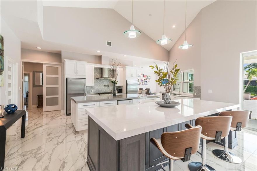 This spectacular four bedroom, four and a half bath home is everything you could ask for in a home on Marco Island. This home boasts over 4,000 square feet under air with an open concept which is great for entertaining family and friends. Nearly everything in this home has been tastefully renovated. Some of the upgrades include expanding to a 3 car garage with a backdoor to the dock, new roof, new lanai deck, new outdoor kitchen, new dock, new seawall, upgraded tile, quartz counter tops, upgraded wooden kitchen cabinets, 2 tank-less water heaters, gas stove with an electric oven, LED lighting, CAT6 cable and so much more.  The brand new dock area is equipped with a boat lift, a secondary slip that can accommodate a 22 foot boat and room to put a 52 foot boat along the seawall. The owner also has installed shore power on the dock. This remarkable home is a must see.