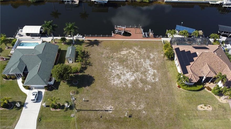 Rare Triple Gulf Access Lot with Seawall, Dock & Lift – Ready to Build!
An exceptional opportunity awaits with this oversized triple Gulf access lot located on the Rococo Canal in NW Cape Coral. Featuring western exposure, this property delivers breathtaking Florida sunsets and the ultimate waterfront lifestyle—all with the heavy lifting already done. The lot is fully improved with a seawall and expansive dock system, allowing you to start building your dream home without delay. The seawall is constructed with 10-foot concrete panels and finished with stainless steel hardware throughout. The dock is designed for serious boating, accommodating up to a 30-foot boat, two jet skis, and space to tie up a 40-foot vessel at the captain’s walk. Boating amenities include a 13,000 lb IMM Platinum Series boat lift with a 12’6” cradle, aluminum bunks, maintenance-free pulleys and bearing blocks, and four 10” lift piles. A 7,000 lb IMM Platinum Series dual jet ski lift with walk board is also in place. Four new 9’ piles are already installed for a future 10x15 tiki hut, and solar lighting enhances both the captain’s walk and dock perimeter.
The dock has received an $18,000 electrical upgrade, including 240V service to the boat lift, dedicated circuits with remote controls, and a Leviton pedestal offering 50-amp and 30-amp shore power, 120V outlets, hose bib, and dock lighting—everything needed for convenience and future expansion. Located in a fast-growing area of NW Cape Coral, this property offers both lifestyle and long-term value. Enjoy quick access to the North Spreader Canal, making trips to Matlacha’s waterfront dining and island charm a breeze. You’re also just minutes from Coral Oaks Golf Course, city parks, the Pine Island Road corridor, and within easy reach of Punta Gorda. Nearby, the highly anticipated Seven Islands development promises future marinas, upscale dining, entertainment, and mixed-use amenities. Build now or plan for the future—opportunities like this are rare. Don’t miss your chance to secure one of the finest Gulf access lots in Cape Coral.