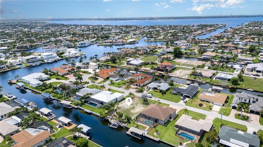 EXQUISITE LOCATION- DIRECT SAILBOAT ACCESS TO THE GULF. Set sail from your own back yard! No bridges to limit your sails and only 5 Minutes to the Caloosahatchee River & open waters. Located near the cul-de-sac of a wide street lined with multi-million dollar homes. This waterfront lot is on an 80' canal, has a well-maintained seawall, a captain's walk, and 7,000-lb Boat Lift (installed 2018). The back of the property is tiered to form an inviting dockside patio with aquatic plants and shade trees. There are also mature fruit trees: mango, avocado, olive, and statement palm trees. The owl burrow at the perimeter can be removed or relocated once you’re ready to build. The Tarpon Point Marina and Rotary Park are nearby for dining, shopping & recreation. City Water & Sewer available. NO Impact Fees. NO Assessments Due.