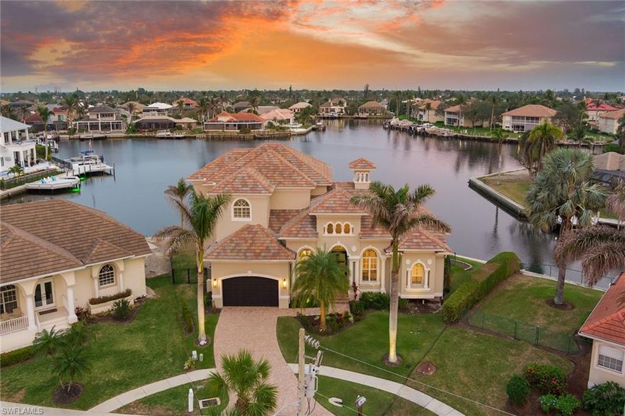 Fabulous wide-water views from this tip lot home. Completely remodeled in 2017, this beautiful, 2-story, Divco home features 5 bedrooms + office and 5 ½ bathrooms. This home has it all including a new roof, new AC, new dishwasher, new refrigerator, new landscaping, new pool heater, new brick paver path walkway to the dock, tray ceilings, impact doors, impact windows, and a whole house water softener. The light and bright living boasts a formal dining area and a breakfast nook. The chef will love the amazing kitchen with plenty of cabinets, stainless steel appliances, electric cooktop, wall oven, pantry, and a breakfast bar. The huge master suite has grand double doors, walk-in closet, water views, an en-suite with a soaking tub, separate walk-in shower, and dual vanities. The office makes a great place to work from home. Great for family time, the upstairs area includes a sitting area, 3 guest bedrooms, 3 baths and privacy. The large, screened lanai offers a covered sitting area, wide, serene water views, a refreshing pool, and a wonderful spa. The large dock with 2 lifts is sure to impress and provides indirect access to the Gulf.