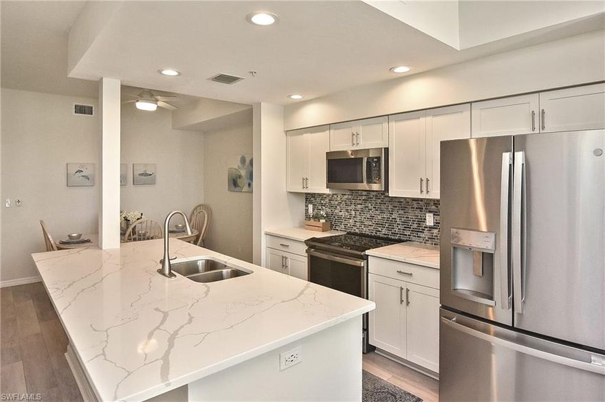 Welcome to your dream coastal retreat! This beautifully updated TURNKEY 2 bed/2 bath condo features over $90,000 in renovations (2022–2023), delivering modern style, comfort, and peace of mind throughout. Major Upgrades Include: luxury vinyl plank flooring; fully renovated kitchen (with new shaker cabinets, expansive one-level quartz countertops, stainless steel appliances and a jewel-toned backsplash); primary bathroom remodel (with new tile, backsplash, stone vanity and neutral flooring); customized window treatments by At Home Blinds and Decor; contemporary light fixtures and ceiling fan; Window World hurricane impact windows; and electric hurricane shutters (in 2017).  Step inside to a light and airy open layout designed for Florida living. The spacious living room offers comfortable leather recliners, a pull-out sofa, and a cozy reading nook—all enhanced by updated lighting that highlights the condo’s modern aesthetic. The newly updated kitchen serves as the heart of the home with its stylish cabinetry, quartz surfaces, and stainless appliances. The spa-inspired primary bath provides a tranquil escape with its fresh tilework and sleek finishes. Enjoy relaxing on the lanai while taking in views of the golf course, serene lake and lighted fountain - creating a peaceful backdrop day and night. This home blends indoor/outdoor living effortlessly, while, with one-touch hurricane shutters, ensures safety and peace of mind in any season. Located in the prestigious Heritage Palms Golf and Country Club, this bundled community offers 36 holes of championship golf, tennis and pickleball courts, a resort-style pool and Oasis/Tiki Bar (completed in 2025), state-of-the-art fitness center, and casual/forming dining. It is an ideal winter retreat or full-time residence for those seeking an active Florida lifestyle. Don't miss this exceptionally upgraded condo!