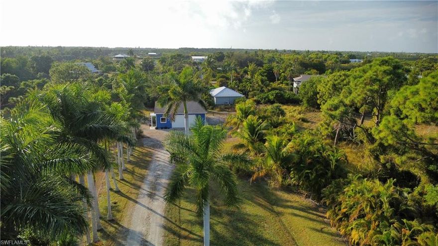 High & dry 2.45-acre Island Ridge property with climate-controlled building—ready to build or use now.

This spacious acreage parcel includes a 26' x 30' insulated building that has AC, with Hardie board siding, a new 2025 roof, an overhead roll-up door, a lanai and three additional entrances. Roof has a transferable WARRANTY to new owners.  Inside, you’ll find beadboard paneling and a smooth concrete floor—ideal for storage, workshop use, climate-controlled hobbies, or future customization. With central water and electric already in place, the groundwork is set for your next step.

There is ample room for all your toys—boats, trailers, trucks, cars, kayaks, and RVs—and the property is horse-friendly and zoned AG 2 so grow your own fruit trees and palms! The driveway is beautifully accented with mature Royal Palms, creating an inviting entry onto the property.

Located on Pine Island, you’ll enjoy the area’s natural beauty, abundant wildlife, and unforgettable Charlotte Harbor sunsets. The island-long bike path is just minutes away, along with local palm and tropical fruit farms. Nearby waterfront restaurants and marinas offer quick boat access to world-class fishing, pristine beaches, and secluded islands.

This one-of-a-kind acreage property offers privacy, flexibility, and tremendous potential—a must-see for anyone seeking space, serenity, and the true island lifestyle. Seller open to buyer incentives with acceptable offer.