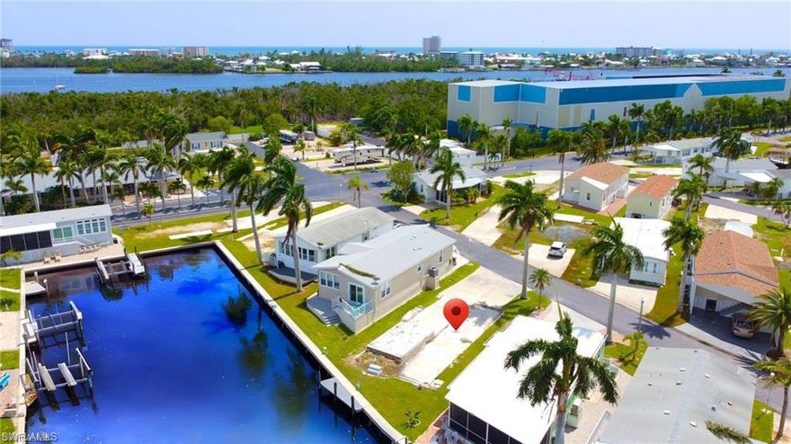 In this dynamic 55+ co-op community that now permits elevated, site-built homes, an excellent opportunity awaits with this vacant waterfront lot featuring a dock and seawall. Enjoy seamless Gulf access with no bridges obstructing your path, allowing you to be on the water in just 15 minutes. The lot is prepared for new construction, with zoning allowing either stick-built or modular homes, so there’s no requirement for a manufactured home. With FEMA regulations requiring an elevation of around 10 feet, you'll benefit from under-home parking, extra storage, or even a recreational area, all without needing flood insurance. Positioned conveniently across from the community pool, the lot also provides access to amenities like a clubhouse, shuffleboard, pickleball courts, and 16 acres of free storage for RVs and boats. Residents can easily stroll to nearby attractions such as Salty Sam's Marina, Parrot Key, Times Square, Bonita Bills, Doc Ford’s, Dixie Fish House, the new Margaritaville Resort, and Fort Myers Beach.