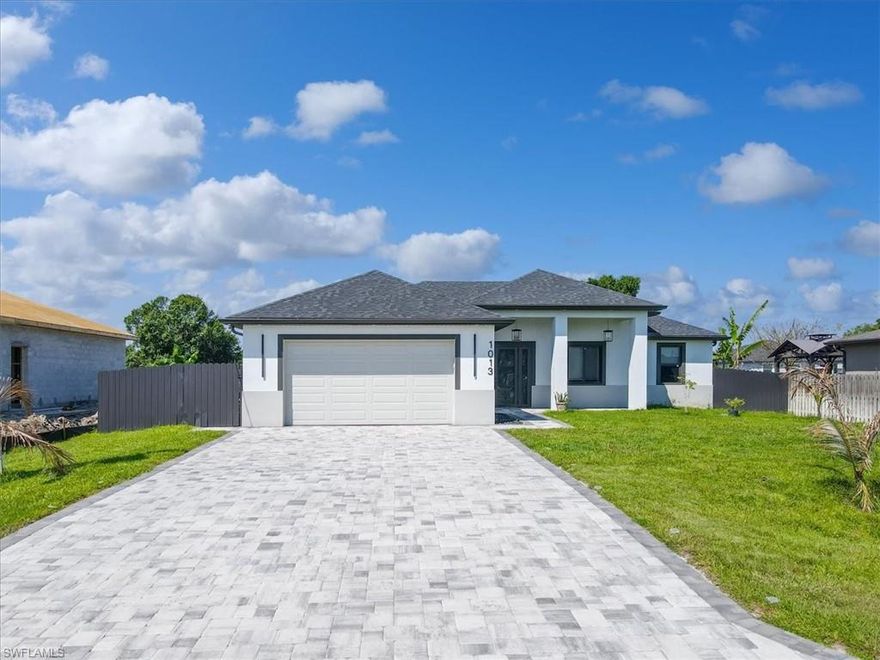 Step into a level of modern luxury rarely found in Lehigh Acres—this fully upgraded home at 1013 Chaplin Ave is truly in a league of its own. Less than one year old, every detail has been thoughtfully designed with high-end finishes and cutting-edge features throughout. Inside, you’ll find soaring tray ceilings, oversized 24x48 tile flooring, shiplap accents, custom California closets, and a stunning entertainment center complete with a sleek digital fireplace. The indoor laundry room is equally impressive, offering quartz countertops and built-in cabinetry for added convenience.

The show-stopping kitchen is equipped with all digital appliances, quartz countertops, a stylish island with foot rail seating, and even an under-the-sink ice maker—perfectly blending function and design. This home offers three private suites plus a half bath, with spa-like bathrooms featuring walk-in showers and illuminated LED mirrors for a clean, modern feel. Smart living continues with an integrated alarm system, digital appliances, and a whole-home water treatment system.

Outside, the upgrades continue with impact doors, a striking modern entry with sidelights, trimmed sliding doors, a brick-paver driveway and back porch, outdoor shower, fruit trees, a fully fenced yard, and elegant exterior lighting. The garage is just as dialed-in, featuring epoxy flooring, built-in tool cabinets, and an additional refrigerator. This is not your typical Lehigh Acres home—this is a near-new, fully loaded, move-in-ready showcase offering unmatched quality, style, and value.