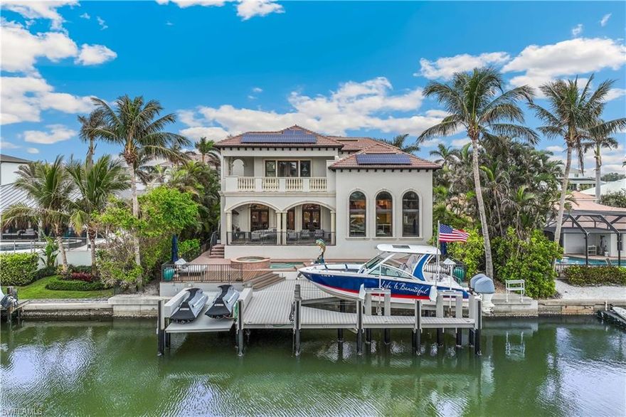 DIRECT GULF ACCESS. This magnificent, high-quality construction home features a 30-FOOT BOAT, 2 JET SKIS, a spacious dock, a powerful 28,000-lb boat lift, a secondary lift for a jet ski, a seawall, and a durable fiberglass deck board. An exceptional opportunity for boating enthusiasts. This Southern-exposure residence has been meticulously designed with every detail in mind. Step through the stunning 10-foot arched mahogany front door and into a spacious, welcoming interior with an open floor plan ideal for both relaxing and entertaining. This quality, custom-designed home is being sold furnished with elegant pieces throughout. Showcasing exceptional craftsmanship and attention to detail, the residence offers 4 spacious bedrooms, a den with custom-built-in shelving ideal for a home office, and 4.5 bathrooms. The light-filled living and dining areas flow seamlessly into a welcoming family room, perfect for entertaining or relaxing. The formal dining and living areas are combined, featuring a fireplace with a wall of French doors leading to an outdoor covered terrace overlooking a wide canal. Notable features include extensive crown molding, high ceilings, hidden A/C vents, impact windows and doors, plantation shutters, and an elevator that provides access to all three levels. Energy efficiency meets modern living with 27 solar panels, Tesla power banks, spray foam attic insulation, and a 3-car garage. A specious family room offers large picture windows, a volume ceiling with wood beams, and is adjacent to a large kitchen. The gourmet kitchen is a chef's dream come true. It is equipped with a six-burner gas cooktop, warming drawer, Sub-Zero refrigerator, wine cooler, stainless steel appliances, a walk-in pantry, breakfast bar, and stunning granite countertops. The primary suite is a true retreat, accessed through double doors and offering a private seating area, two spacious walk-in California closets, and a private balcony for quiet moments outdoors. The luxurious en-suite bathroom features dual vanities, a Jacuzzi tub, a bidet, and a separate large walk-in shower. Each guest bedroom includes its private bathroom, with one bedroom conveniently located on the first floor, perfect for hosting guests. The outdoor space is just as impressive as the interior, featuring a spacious lanai, a fully equipped outdoor grill, ample lounging areas both covered and open, and a heated pool and spa to create a favorable entertaining space for family and friends or enjoying peaceful, private evenings. With the Gulf just minutes away by boat, a 30-foot boat, 2 jet skis, and the BEACH a SHORT STROLL away, enjoy the best of Naples waterfront living in the highly sought-after Vanderbilt / Conners area has to offer. Conveniently located close to Marcatto Shopping Center, Whole Foods Market, Restaurants, Golfing, and many other attractions, this is more than a home-it's a lifestyle! Unbeatable Location!