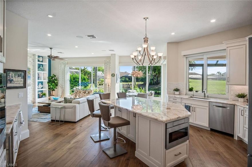 PERHAPS THE FINEST HOME EVER OFFERED IN SPANISH WELLS! Completely renovated and re-imagined, this spectacular residence is perfectly positioned on a premium lot with sweeping long lake and golf course views. The home has been extensively upgraded and thoughtfully redesigned, featuring a NEW MODERN CONCRETE TILE ROOF (2018), NEW HVAC SYSTEM (2021), HURRICANE-IMPACT WINDOWS AND DOORS, and extraordinary natural light that pours through oversized impact glass windows—beautifully framing the tranquil water and golf course vistas. The contemporary interior showcases an open and inviting floor plan with HIGH-END HARDWOOD and tile flooring throughout, 4 bedrooms (4th bedroom currently set up as an office), and 3.5 baths, while the elegant living room is highlighted by a striking stone accent wall with fireplace & custom built-ins. The designer CHEF’S KITCHEN features beautiful white cabinetry, premium appliances including a THERMADOR gas cooktop & BOSCH stainless steel appliances with side-by-side ovens, CRISTALLO countertops, soft-close cabinetry and drawers, and a spacious layout perfect for everyday living or hosting guests. The luxurious primary suite offers private access to the lanai along with a spa-like en-suite bath featuring TAJ MAHAL quartzite countertops, dual vanities, and a large glass-enclosed shower. Additional upgrades throughout the home include electric shades and plantation shutters, whole-house reverse osmosis and soft water systems, LG pedestal washer & dryer with storage drawers, SOLAR PANELS on three sides of the roof, and an extra-wide impact-resistant garage door with decorative sidelights. Step outside to your private outdoor oasis featuring a stunning SALTWATER POOL AND SPA BUILT IN 2021 with a tanning shelf, marble lanai, and spacious covered lounging areas, all enclosed by a picture-screen enclosure that allows for unobstructed panoramic lake & golf course views. ENJOY GOLF AT THE SPANISH WELLS GOLF COURSE WITH NO MEMBERSHIP REQUIRED! Or, Spanish Wells offers flexible membership options to suit every lifestyle, including a low-cost golf membership OR sports membership with unlimited use of the driving range, practice facilities, fitness center, tennis, pickleball, bocce, reciprocal privileges & discounted golf rates, or a social membership with dining privileges, pool access & vibrant community events. All amenities identified in listing, with the exception of Public Golf, are available only with a membership to the Spanish Wells Country Club. Ideally located in the heart of Bonita Springs, Spanish Wells is just 10 minutes from the world-class beaches of Bonita Beach and Barefoot Beach and only minutes to Downtown Bonita Springs, Mercato, Coconut Point & RSW International Airport—placing the very best of Southwest Florida dining, shopping, & entertainment at your fingertips. High-end custom furnishings are negotiable, offering a rare opportunity to move right into one of the most beautifully renovated homes in Spanish Wells.