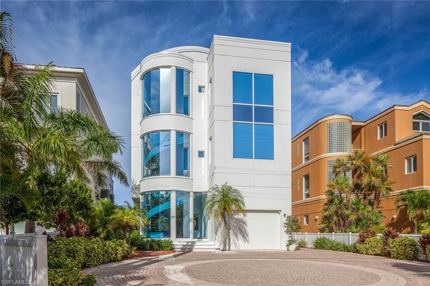 This contemporary masterpiece is located on the Gulf shores of Bonita Beach, just north of the Naples metropolitan area. Designed by Randall Stofft, this three-bedroom home with three full and two half bathrooms features a poured reinforced concrete and glass exterior and three levels of interior space with a floor-to-ceiling wall of windows on each level overlooking the Gulf. Exquisite interior features include a dramatic spiral floating staircase serving all three interior levels and a modern sparkling chandelier traversing the center of the spiral. The open-concept floor plan, white marble floors, all-white kitchen and curved hallways serve to continue the contemporary theme throughout the home. A separate exterior spiral staircase provides access to the rooftop terrace complete with a central bar area. A private elevator and a dumbwaiter also provide access to all three main levels of living plus the rooftop terrace. The lower level of the home features a large game room which leads to the outside patio area. Outside features along the rear of the home include a swimming pool and spa overlooking the Gulf providing breathtaking sunsets. Includes home warranty plan.