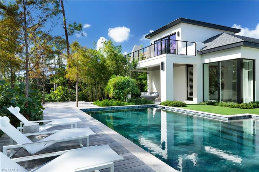 This one of a kind, Frank Lloyd Wright inspired, masterfully designed, custom built two-story estate is certain to delight even the most discerning guests. Enter the grand oasis through a picturesque courtyard via the intricately designed walkway surrounded by lava rock and captivating lush landscaping. Serenity and luxury abound in this delightfully modern estate with exquisite attention to detail in absolutely every aspect. Rich light wood floors flow throughout the main living areas with custom lighting fixtures and volume ceilings adding grandeur to the flowing open floor plan. Expansive floor to ceiling windows allow abundant natural light to flood into the spa-inspired master suite, with private outdoor access. The outdoor space of this exquisite home is absolutely breathtaking – tall stalks of bamboo surround the 60ft sparkling lap pool and boardwalk pathways, leading you to perfectly manicured grounds, expansive covered dining and lounging spaces and a built in fire pit, creating a true oasis.