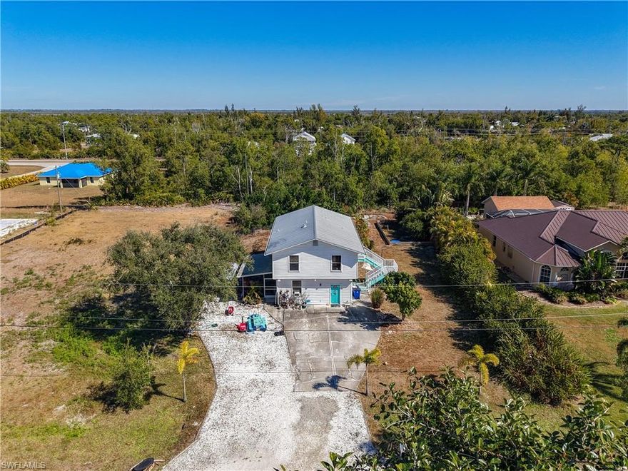 Located on a quiet street in the heart of Saint James City. Situated on Florida’s largest island—a true boater’s paradise—this home offers incredible peace of mind with a metal roof and a rare history of no flooding. The layout is unique and functional, featuring a private primary suite and a large living room on the first floor. Upstairs, the home opens up with a second family room, the kitchen, a dining area, and two guest bedrooms, all with natural light. With both interior and exterior stairs and a spacious side patio, this home is built for easy transitions and enjoying the coastal breeze. The outside of this property is just as impressive as the inside, featuring a massive yard with plenty of room to breathe. Whether you’ve been dreaming of building a pool, adding a large workshop, or just need a secure spot to park your boat and RV, this oversized lot can handle it all. It’s rare to find this much space on Pine Island with a home this large. If you are looking for a comfortable, worry-free home with room to grow and play, this is the one you’ve been waiting for.
