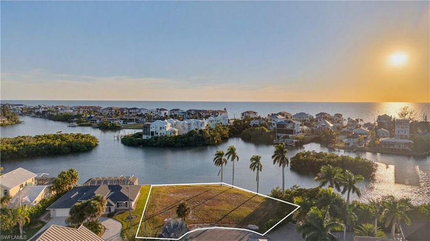 EXCEPTIONAL BAYFRONT HOMESITE WITH 188 FT OF WATERFRONTAGE AND WEST/SOUTHWEST EXPOSURE located at the end of the McLaughlin Blvd peninsula with EXTRAORDINARY WRAPAROUND WIDE BAY VIEWS and just a SHORT WALK TO THE BEACH! Build your dream home in the highly coveted “Carolands” neighborhood of Bonita Beach! With prime West/Southwest exposure, this premier Gulf-access homesite offers breathtaking sunsets and stunning Gulf views from the upper levels of your future residence. A paradise for boating and beach lovers, this property features deepwater access suitable for sailboats, a quick 5-minute boat ride to the Gulf, and an updated seawall. Fantastic opportunity to build your home to your exact specifications & desires with all the newest building codes. With no HOA fees or rental restrictions, this homesite offers exceptional flexibility—ideal for a full-time residence, seasonal escape, or lucrative investment opportunity. All located just minutes from top dining and shopping, just minutes from Mercato, The Promenade, Waterside Shops, Coconut Point, 5th Avenue, and the International Airport.