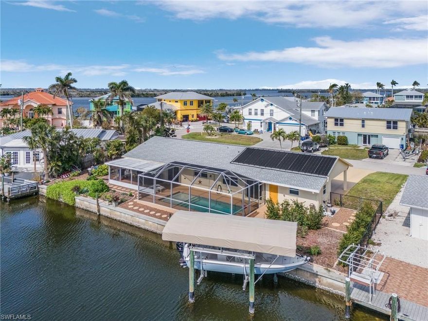 WHETHER YOU'RE LOOKING FOR A SAVVY INVESTMENT PROPERTY OR A PERSONAL WATERFRONT RETREAT, THIS RARE OPPORTUNITY IN STUNNING MATLACHA DELIVERS BOTH.  This UNIQUE DEPLUX with 128' of waterfront, GULF ACCESS, salt water solar heated pool, 7k covered boat lift, all situated on 2-LOTS in beautiful colorful Matlacha.  This property is ideal to be used as an AIRBNB VACATION RENTAL/ANNUAL RENTALS Or as a SINGLE-FAMILY RESIDENCE with a MOTHER-IN-LAW-SUITE. This property's has great versatility with a back-to-back interior double keyed locking door connecting the units while still providing private separate exterior entrances and covered parking for both. The enclosed lanai and pool area serve as a shared common space for both units with individual access through sliding glass doors. This property is equipped with total impact resistant windows and doors throughout, two full kitchens with stainless steel appliances and granite countertops. A common laundry area, as well a large storage room. The 7000lb covered boat lift with fish cleaning station is perfectly situated to maintain the beautiful canal views from both units.  Additional features of the home include a 2020 roof, 2017 saltwater pool with tanning deck, a new pump and solar panels. The spacious side yard offers room for a RV with existing electrical hook ups. Also, the property is fully fenced and has double gates for easy access and safety. This property has been well thought out and extremely well maintained. Experience the best of Florida living either by using as INCOME PRODUCING INVESTMENT PROPERTY or enjoying it as YOUR OWN BEAUTIFUL FLORIDA HOME to share comfortably with guests and family.  Just two minutes from your dock to Matlacha Pass, you will enjoy all the best that The Gulf of Mexico has to offer and the ultimate island lifestyle.  DON'T MISS THIS RARE OPPORTUNTIY IN THE HEART OF ICONIC MATLACHA FLORIDA.