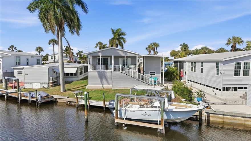 Experience the best of waterfront living in this nearly new, custom built, 2023 elevated residence, ideally positioned on a direct-access canal with no bridges and no lifts, just 2.5 miles from Fort Myers Beach. Boating enthusiasts will appreciate the private dock and remote-controlled boat lift, providing effortless, immediate access to the open waters of the Gulf with no waiting in line for community lifts. This exceptional property represents a rare opportunity for the discerning waterfront buyer.

The home features two spacious bedrooms and two beautifully appointed baths, complemented by a bright, open-concept design. The primary suite offers a beautiful en-suite bath with dual sinks, a luxurious shower, and a walk-in closet. The expansive kitchen with center island and gray shaker cabinetry flows seamlessly into the grand living area, where oversized sliders open to the covered porch. Both the living and dining areas enjoy peaceful canal views, creating an inviting setting for both everyday living and entertaining. An interior laundry room with washer, dryer and additional storage adds everyday convenience.

Step outside to the large covered porch overlooking the canal, a gentle retreat where sunlight dances on the water and passing wildlife becomes part of the everyday scenery. The lower level offers additional entertaining and cooking areas,  along with an outdoor storage shed with electricity—perfect for organized storage, projects, or waterfront gear. The area beneath the home provides generous additional storage, perfect for equipment, tools, or seasonal items. Hurricane shutters on every window, elevated construction, and two sets of comfort stairs provide both security and ease of access.

This home is move-in ready and offered fully furnished—turnkey, excluding select personal items and artwork. Ideally located within walking distance to the pool, clubhouse, and community activities, the property is situated in Bayside Estates, a vibrant 55+ boating community offering a rich calendar of social events, excellent amenities, and an active waterfront lifestyle.