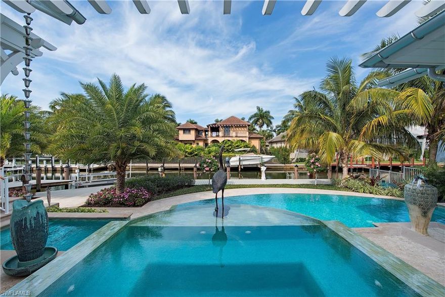 This remarkable contemporary beach home, located on a serene, exclusive street, is just a four-minute stroll from the pristine shoreline and the upscale dining and boutiques of 3rd Street. Designed by renowned architect Matt Kragh of MHK, this masterpiece boasts a canal-front setting complete with a notched boat dock and a 12,000 lb. low-profile lift, offering a swift 15-minute ride to Gordon Pass. Every detail of this home
celebrates refined craftsmanship: exquisite wood feature walls, custom pecky cypress accents, and beams handcrafted from 500-year-old heartpine. Throughout, wide-plank Legno Bastone oak flooring is elevated by hand-set sea glass tile inlays, while the entryway and walkways showcase individual sea glass tiles encased in marble, adding a luxurious touch. Ideal for entertaining, the great room seamlessly balances
grand open spaces with cozy, intimate corners. The adjacent lanai opens directly off the chef's kitchen, perfect for indoor-outdoor dining.
Outside, a two-level spa and an infinity-edge glass-tiled pool blend harmoniously with the lanai, creating an effortless transition between indoor and outdoor living. Built with the tropics in mind, the home is wrapped in a premium German-engineered insulation system for exceptional climate comfort and sustained zero storm damage. This estate embodies luxury, resilience, and timeless elegance