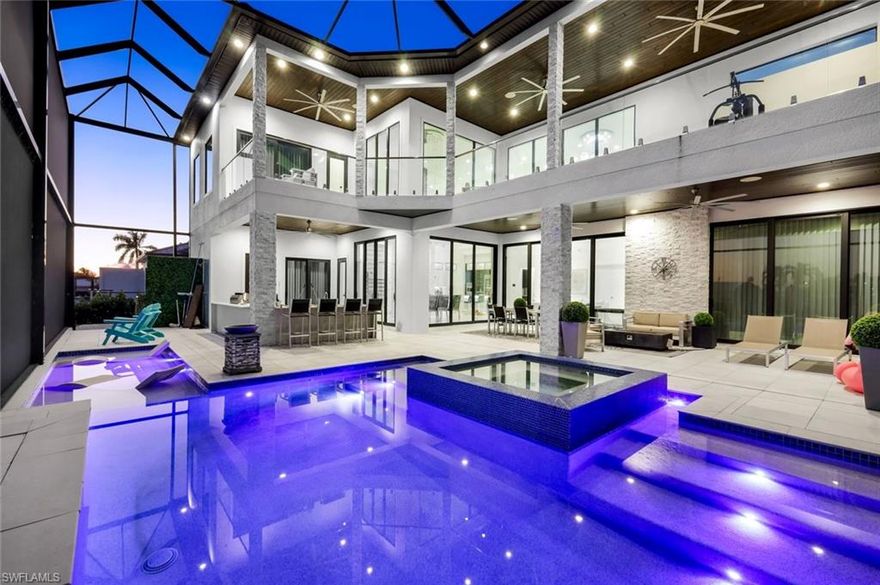 Direct Gulf Access Newer Home with Riverfront Views in the Yacht Club. Walking distance to Cape Coral’s only beach!  Experience luxury coastal living at its finest in this newer custom home with breathtaking riverfront views and Direct Sailboat Gulf Access located in the heart of the prestigious Yacht Club area—modern construction featuring 4,516 SF of extraordinary detail and design. 4 Bedrooms, 4.5 Bathrooms, and 3 Car Garage with modern glass garage doors. No expense spared, loaded with upgrades, superior craftsmanship, timeless elegance, and the ultimate Florida Boating Lifestyle. Step through the grand double doors into a dramatic, open living area with two-story ceilings, floor-to-ceiling windows, and pocketing glass doors that create a seamless transition between indoor and outdoor living spaces. Living Room with 2-story ceilings and a feature wall featuring an oversized electric fireplace creates an awe-inspiring space to relax or entertain. Gourmet kitchen features Viking appliances, a side-by-side oversized refrigerator & wine cooler, a built-in Miele espresso maker, and designer cabinetry. Entertain in style with double waterfall-edge islands offering abundant seating and storage. A floating staircase framed by a stacked stone wall and a glass elevator connects the two levels. The 1st-floor master suite offers pool access and water views, a spa-inspired bath featuring floating vanities, a designer soaking tub set beneath a chandelier, and a walk-through shower. Each guest suite features its own en-suite bath, walk-in closet, and 11 to 13-foot ceilings. With accommodations like these, your guests may never want to leave! Every detail has been thoughtfully designed, including imported tile floors throughout, level 5 drywall, designer lighting, tile-clad feature walls, and surround sound indoors and out. Upstairs, the balcony overlooks the Yacht Club and Caloosahatchee River, providing endless water views and stunning sunsets. Step outside to your private resort oasis featuring a heated pool with an integrated infinity-edge spa, southern exposure for maximum sunshine, and an oversized under-truss lanai with 1,785 square feet of outdoor living space. Entertain poolside with the fully stocked outdoor kitchen and wraparound bar, featuring seating for 8, wood ceilings, a sound system, a cabana-style lounge area with a fireplace and TV, and an outdoor shower. Sunbathe waterside in the sun shelf! Boaters: FAST open-water access in minutes, an 80-foot composite dock with a captain’s walk, a high-capacity boat lift, power & water, and a jet ski lift. BEACH BOATING AND LUXURY. Located moments from NEW Bimini Square, The Cove, Slipaway, and the Yacht Club’s revitalized marina and expanded beach, this residence offers unmatched proximity to Cape Coral’s most exciting waterfront dining, entertainment, and boating destinations, with more on the way! Hurricane Impact Windows & Doors - No water intrusion or significant damage during any storms.