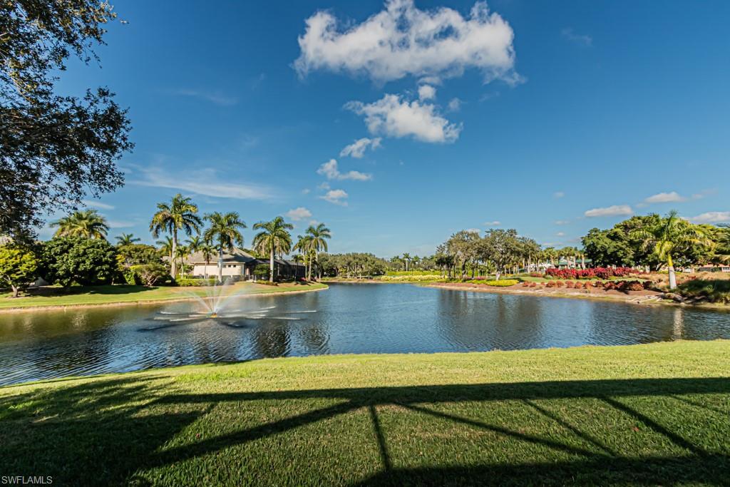 Lakeside view in Marsh Links community, featuring fountain, palm trees, and lush landscaping, highlighting serene outdoor space near luxury property in Naples, FL.