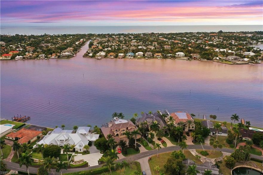 Embraced by a magical waterfront setting, this stately 5BD/5.5BA bayside home w/new roof is a remarkable opportunity in the highly regarded ROYAL HARBOR, minutes to the beach. A maestro of perfect, you can toast to the good life on the expansive verandah & its impeccable outdoor kitchen, swim in the beautiful negative-edge bayside pool/spa, or take your boat out for a spin from your private dock w/lifts. Inside, you will find an amazing collection of living & dining spaces in collaboration w/the culinary perfection of the gourmet kitchen w/immense prep island & gas range. The exquisite architectural details highlight elegant tray ceilings & walnut coffers alongside gleaming Travertine floors, walls of glass doors & a classic stone fireplace. The main floor master w/2 walk-in closets & guest suite w/verandah access offers comfortable respite, while upstairs houses two guest suites & 2nd master, all w/private balconies. A spacious upstairs den & full kitchenette make entertaining a breeze!  (Must Watch Our Professional ''Live Video Tour''). This is the best snook fishing off the dock on Naples Bay that you can find!