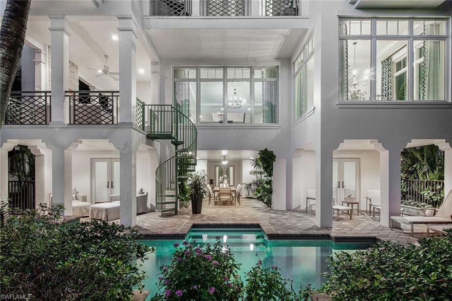 Beach. Boating. Bliss. Spectacular residence at Naples Casamore built by BCB Homes and furnished by The Striped Cabana. Sophisticated entry with custom arched wood door, shell reef stone flooring, and French doors that open onto lush tropical outdoor living area. Interior highlights include custom rod-iron railings, detailed tongue and groove ceilings, hand-scraped wood flooring, and a multitude of Andersen windows redefining the term, light, bright and airy. Open floor plan, with living, dining, and kitchen flowing out to a spacious covered terrace with Gulf views, gas fireplace, and a spiral staircase down to the pool. Generous eat-in kitchen includes Brookhaven white cabinetry, top-of-the-line appliances, and large walk-in pantry.  Exceptional master with dual luxurious marble baths, custom walk-in closets, and private access to the observation deck which boasts spectacular views of the Gulf of Mexico. The expansive outdoor entertaining area includes a private pool with spa, outdoor shower, and easy access to the docks and private beach access. This residence has exclusive use of two slips, one with a lift and the other with a jet ski or other water sports platform.