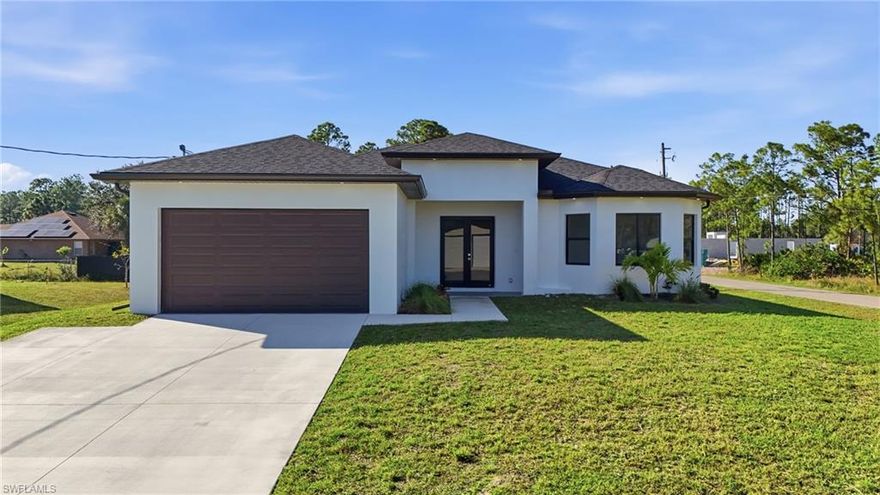 Brand-new construction home located on a desirable corner lot in Lehigh Acres! This beautifully designed modern residence offers open living spaces, sleek finishes, and an ideal location just minutes from Harns Marsh Preserve, shopping, dining, schools, and daily conveniences. Enjoy a bright open-concept layout with high ceilings, large tile flooring throughout, and plenty of natural light. The contemporary kitchen features white cabinetry, stainless steel appliances, pendant lighting, and a spacious island—perfect for cooking and entertaining. The primary suite provides a relaxing retreat with a stylish bathroom and generous closet space. Large sliding glass doors open to the backyard, offering room to create your ideal outdoor living space. With a two-car garage, fresh new build quality, and a peaceful setting surrounded by newer homes, this Lehigh Acres corner-lot home delivers comfort, convenience, and Florida living at its finest!