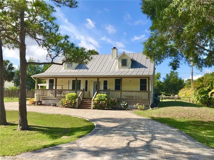 Welcome home to this 2003 Bokeelia beauty- Classic island charm exudes forth with an open front porch, carefree vinyl siding, impact windows, metal roof with dormer attic windows and horseshoe drive with pavers. Inside you'll find volume ten foot ceilings throughout, a fireplace, 3/4" solid Hickory floors in the living room, dining room and hallway, custom Hickory kitchen cabinets, solid surface kitchen counters and ceramic tile in all wet areas. Master bedroom suite has dual sinks, dual closets and a large cultured marble shower with a back door just in case you add a pool. Across the house is the guest bedroom and bath with a Safe Step Walk in Tub, and a separate laundry/mud room with a large storage closet. Around the back you'll find a large screened back porch, a huge fenced double lot back yard with a majestic Live Oak and storage shed. Seller combined all 4 lots which equals .37 acre; seller stated Lee County said the 2 South lots can be split back off and a house built on each one, buyer to verify.  Enjoy island life with shopping, marinas, community pool, parks, hiking trails, 18 hole golf course, restaurants, art galleries and more!