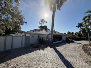 Single-family home in Palm River Estates, Florida, featuring a paved driveway, palm trees, and a sunny exterior view, emphasizing spacious lot and landscaping.