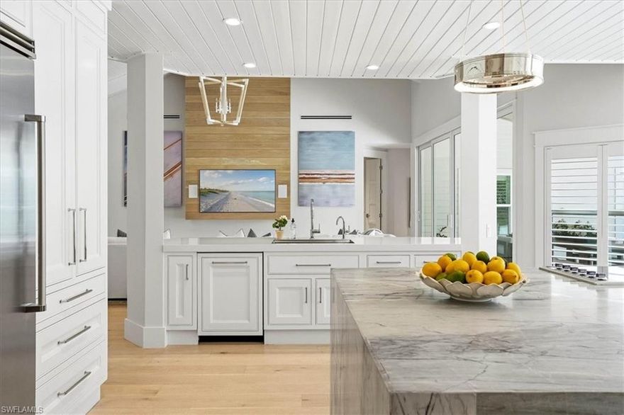 Welcome to a completely reimagined Old Florida retreat where timeless charm meets refined luxury. Thoughtfully remodeled from top to bottom, this exceptional estate delivers an entirely new living experience set on nearly one and a half acres of lush, private grounds. Featuring 4 bedrooms + den + loft, 4 full bathrooms, 2 half baths, and over 5,000 square feet of living space, the home offers an extraordinary blend of expansive design and elevated comfort—perfectly suited for both everyday living and sophisticated entertaining. The main residence features three bedrooms, a den, and a versatile loft, highlighted by soaring vaulted ceilings and abundant natural light that fills every room. The expansive chef’s kitchen is designed to impress, showcasing new appliances, a generous island, a walk-in pantry with built-in shelving and refrigerator and freezer, and a custom wine bar ideal for hosting gatherings. The primary suite serves as a tranquil retreat, complete with a walk-in closet featuring custom shelving and a spa-inspired bathroom with a walk-in shower, soaking tub, and dual vanities. Adding to the property’s versatility, a separate guest house above the three-car garage offers a private bedroom, full bathroom, kitchen, and living area, along with its own dedicated driveway and gated access, creating the perfect private space for guests. Outdoors, the property transforms into a true private oasis. Enjoy a sparkling pool, outdoor dining space, new infrared sauna, and a new fire pit, all designed for relaxation and entertaining. The butterfly garden, curated with species-specific plantings, is complemented by professional Koby Kirwin landscaping, creating a breathtaking natural backdrop enhanced by new landscape lighting and mature privacy hedging. Every major system has been replaced, including the roof, HVAC and ductwork, septic, water well, filtration system, underground drainage, irrigation, culverts, driveway, and access gates, providing peace of mind and modern efficiency. Ideally located just minutes from Vanderbilt Beach, Waterside Shops, Mercato, Clam Pass Park, and the Village Shops on Venetian Bay, this remarkable property represents Naples, Florida living at its absolute finest.