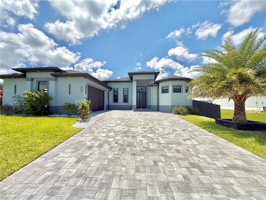 Beautifully Luxury 3-bedroom plus den home located in NW Cape Coral with easy access to Burnt Store Rd. Situated on an oversized triple lot, this property offers plenty of space along with a fenced yard and an additional driveway for boat or trailer.

This home features impact windows and doors, a climatized garage with epoxy flooring, built-in cabinetry, and windows providing natural light—perfect for a man cave, playroom, or additional living space. 

Inside, you’ll find high-end finishes throughout, including waterfall countertops, soft-close cabinetry, luxury granite surfaces, custom closets, and a striking wood accent wall in the living area—along with a dedicated office with custom cabinets and workspace.

Enjoy Florida living at its best with a 14x30 pool and infinity spa and sunshelf, both equipped with a smart system and heater. The outdoor space is designed for entertaining, featuring a picture window cage, expanded deck, outdoor shower, and a fully equipped kitchenette with L-shaped quartz waterfall counter, built-in grill, gas burners, sink, and mini fridge. A separate paved patio area offers additional space for a fire pit or gathering area.

The professionally landscaped yard includes a variety of palm and fruit trees, along with programmable landscape lighting. Additional features include a whole-home reverse osmosis system and LED soffit lighting.