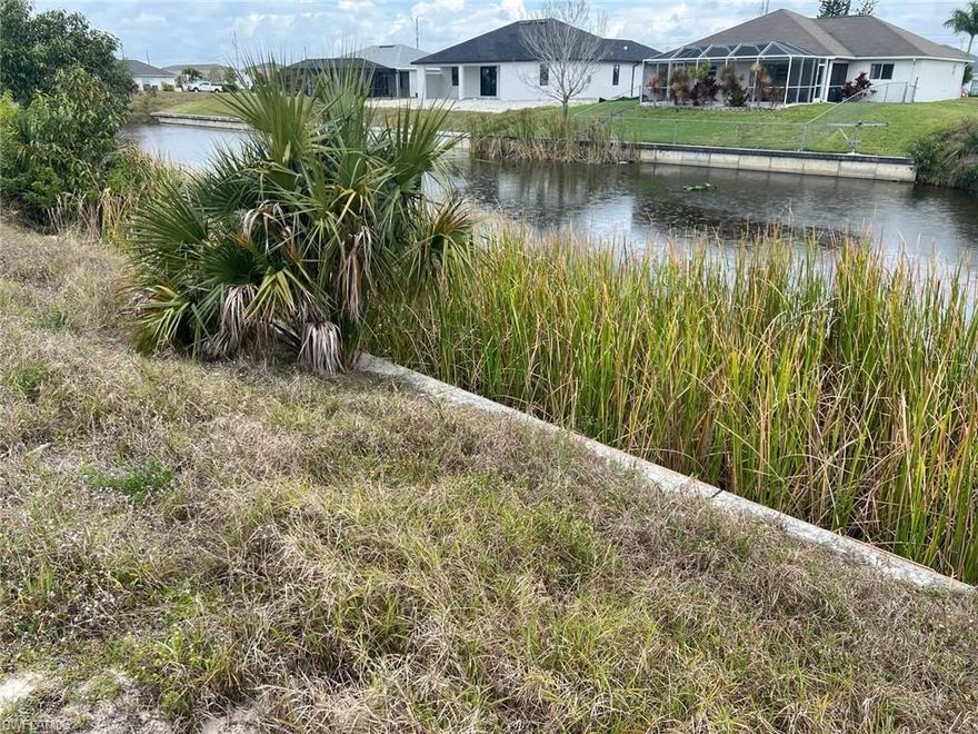 Embrace waterfront living on Cape Coral's Freedom Canal. This vacant lot presents an ideal canvas for your dream home, complete with a pre-installed seawall offering peace of mind and endless possibilities.