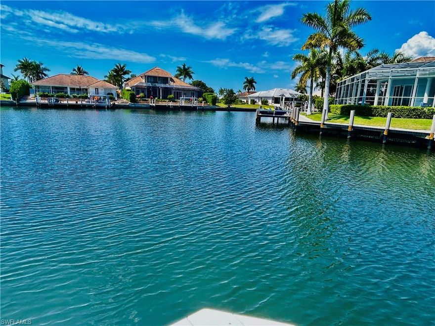 Experience true Marco Island living in this beautifully updated waterfront home, offering modern upgrades, expansive outdoor space, and stunning wide water views. Situated at the end of a quiet cul-de-sac, the property features a brand-new 111-foot seawall with a 25-year transferable warranty, along with a custom-built 800+ sq ft dock accommodating up to a 32-foot boat. A new 16,000 lb boat lift is also included, all with transferable warranties—perfect for boating enthusiasts. The home boasts a spacious, light-filled interior with fully retractable patio doors that seamlessly blend indoor and outdoor living. The large screened-in pool area with covered panoramic enclosure provides the ideal setting for relaxing or entertaining while enjoying serene water views. The modern kitchen is equipped with sleek cabinetry, black granite countertops, built-in oven and cooktop, and high-end appliances, including a Bosch integrated, ultra-quiet dishwasher. The dining area is perfectly positioned to take full advantage of the waterfront scenery. All bedrooms are generously sized with large windows that fill the space with natural light, many offering water views. The primary suite features a luxurious bathroom with a double walk-in shower with multiple shower heads, soaking tub, dual vanities, and contemporary finishes, along with a dedicated dressing area. The guest bathroom has also been tastefully updated. Additional upgrades include impact-rated Low-E windows (2021), a new roof and gutters (2018), new pool, deck, and lanai (2019), multi-split A/C system (2023), water heater (2020), pool heater (2025), and a newly paved driveway and patio (2026). The two-car garage includes a large hidden storage area behind stylish barn doors. This exceptional property combines modern comfort, quality upgrades, and prime waterfront living in one of Southwest Florida’s most desirable locations.