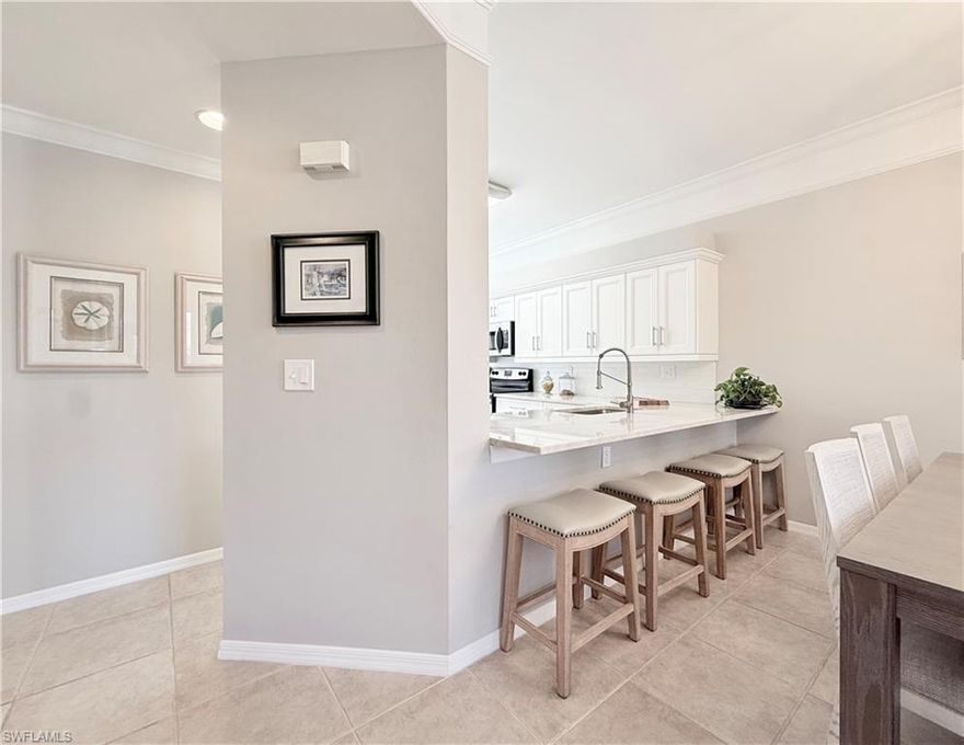 END UNIT 2 BR + DEN CONDO in Naples Heritage Golf and Country Club with deeded golf membership. This well-appointed residence offers 1,408 square feet of thoughtfully designed living space, combining comfort, style, and beautiful views.  From the moment you enter, you’ll appreciate the abundance of natural light enhanced by additional end-unit windows. The renovated kitchen is both functional and inviting, featuring white cabinetry, white subway tile backsplash, beautiful natural stone Taj Mahal countertops, stainless steel appliances, and a breakfast bar lowered to counter height. A custom pantry with pullout shelving provides exceptional storage, while the charming eat-in dining area showcases a built-in bench designed for both seating and storage.  The open-concept dining and living areas create a bright and welcoming space ideal for relaxing or entertaining. Just off the main living area, the den offers flexibility with pocket doors for privacy, making it perfect as a home office, guest room, or additional lounge space. Plantation shutters throughout the home add both elegance and privacy.  The split-bedroom floor plan ensures comfort for both owners and guests. The spacious primary suite enjoys tranquil views of the lake, golf course, and preserve, along with two walk-in closets. The ensuite bath has been tastefully updated with a newer vanity featuring a beautiful natural stone countertop, framed mirror, updated lighting, walk-in shower, and linen closet. The guest bedroom is privately located and also offers a large walk-in closet, while the guest bath has been updated with a newer vanity, framed mirror, and lighting.  Additional highlights include a full-size walk-in laundry room, a private exterior storage room, and hurricane shutters on both the lanai and windows for added peace of mind. The screened and covered lanai is the perfect place to unwind and enjoy the peaceful surroundings.
Residents of Naples Heritage enjoy a vibrant bundled golf lifestyle with an 18-hole golf course, practice facilities, resort-style pool with cabana bar, tennis complex, pickleball courts, and a fully equipped fitness center with weight and cardio rooms, along with studios for instructor-led classes. An active social calendar and clubhouse with both indoor and outdoor dining complete the experience.  Conveniently located just minutes from Fifth Avenue South, you’ll enjoy easy access to fine dining, shopping, entertainment, and the beautiful Gulf beaches—offering the perfect blend of resort-style living and coastal convenience.