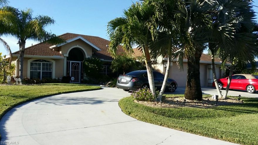 ABSOLUTELY GORGEOUS home and views!!!  
180 degrees of SW to NW Basin, Canal AND Intersecting Canal views that lead to the Gulf of Mexico from this over sized triple lot home site with nearly 2000 sq ft under air with room to add onto the home currently 3 bedroom 2 bath (large Jack and Jill bath connects between 2nd and 3rd bedroom) along with Den currently set up as office furnishings that convey with sale.  An inside utility room leads to 2 car garage plus adjoining man cave / motorcycle / golf cart / extra storage Garage with its own side door entry and garage door.  Two sets of glass sliders fully open creating spacious indoor outdoor living space to enjoy full size Tiki Bar under truss, pool with vanishing edge and large open picture screen views to basin, AND your own putting green! (easily removed if not desired)  At Your Dock offers large wrap around dock with boat lift, tiki hut with table and extended concrete dock along half of the seawall.  Exterior of home offers full hurricane shutters, fruit trees and landscape pond with water feature and possibly KOI.  For private showing in person or VIRTUALLY from the comfort of your location contact to schedule showing TODAY!!!