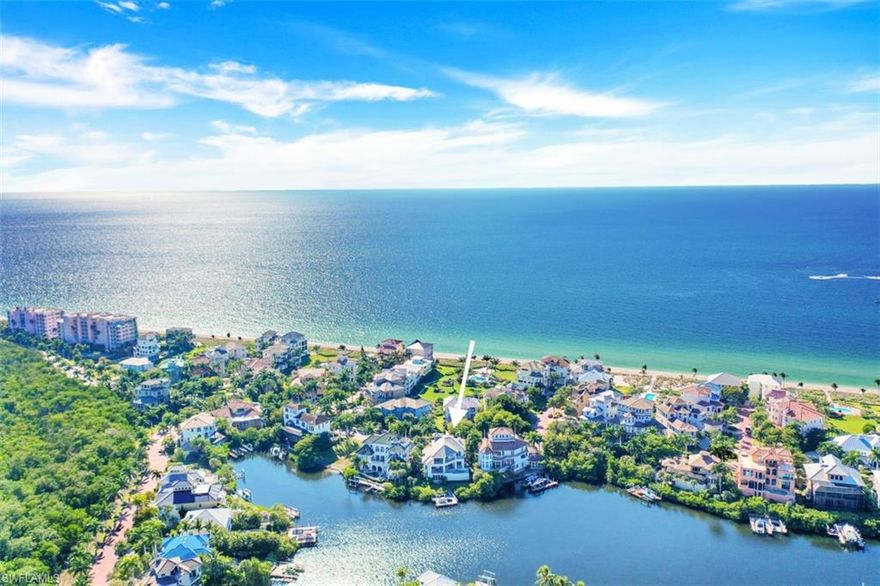 Behind the guard-gated waterfront enclave of Barefoot Beach, 232 Barefoot Beach Blvd is sublimely situated between the Beach and Bay. This masterpiece offers breathtaking Bay views through floor-to-ceiling retractable glass doors. Brimming with refined elegance & custom designer touches, this estate boasts 5 bedroom suites, a 3 car garage, elevator & a private boat dock/lift.  The gourmet kitchen features an enormous island, stunning quartz counters, Thermador & SubZero appliances, double wall oven, an adjacent dining area & a wet bar with Virtrazzo counters, martini-fridge & dual temperature SubZero wine cooler. An exceptional outdoor oasis boasts seamless indoor-outdoor entertaining with a glistening pool/spa, ample seating, and a summer kitchen with gas grill. Upstairs, 4 private suites offer a tranquil retreat for your guests. The lush landscaping provides a tropical setting with lime & lemon trees. Additional features include Lutron lighting, engineered Maple hardwood floors, security Ring doorbell with all-door security sensors, electric screen/shutters, bonus room/flex space with wet bar, massive top-floor lanai. Just a stone's throw from the beach, LUXURY awaits you here!