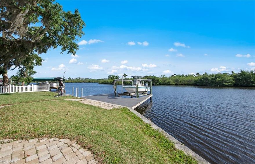 We offer an amazing opportunity to own almost ¾ acre of river front property located in the River Forest community and situated on a protected oxbow of the Caloosahatchee River. Water carries good depth to accommodate most any vessel. There is a beautiful view across the oxbow of a protected island full of natural wildlife. The water front has a concrete seawall with composite dock and boat lift as well as a floating dock to accommodate 2 jet skis. There is also a new 1,100 SF masonry accessory building with OH garage doors and storm shutters. The landscape has been enhanced with an area of tropical gardens with paver pathways including irrigation and lv night lighting. The property is totally fenced with vinyl privacy fencing. There is an RV motorcoach parking pad with utilities. There is an existing home on the property that was flood damaged in Hurricane Ian. The home was cleaned out and drywall removed……This is an excellant oppertunity to build a new home to current FEMA standards on a completely improved 3/4 acre property with utilities in place and NO Impact fees for new construction !!