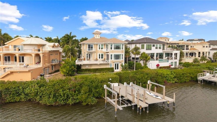 Nestled in the coveted enclave of Barefoot Beach, this coastal masterpiece delivers the rarest combination—boating and beach access—on one of the community’s most desirable waterfront sites. Recently enhanced with a new roof, the home spans an impressive 5,079 sq. ft. of refined living space, offering 4 spacious bedrooms, 4.5 baths, and a dedicated study.

An additional 1,432 sq. ft. on the lower level extends the home’s livability with a boat room, exercise room, game room, and an oversized 3-car garage designed for the Southwest Florida lifestyle. The private dock is fully equipped with a 16K boat lift plus a platform lift ideal for kayaks or jet skis, giving you effortless access to the Gulf.

A raised pool and spa overlook the shimmering shoreline, capturing breathtaking sunrises and creating a serene backdrop for outdoor living. Inside, a Bermuda-style great room and separate dining area flow into a bright kitchen and inviting family room, all oriented to maximize the sweeping water views.

The primary suite is a true retreat—elevated, tranquil, and reminiscent of a luxury cruise ship—with a soaking tub, jetted shower, sitting area, and panoramic vistas. An elevator services all three floors, ensuring ease and comfort throughout the home. All windows and doors are impact-rated or shuttered for peace of mind.

After a morning on the water, enjoy a leisurely stroll to the beach just minutes from your front door. Lovingly maintained and thoughtfully updated, this residence offers pristine condition, timeless design, and an unparalleled Barefoot Beach lifestyle