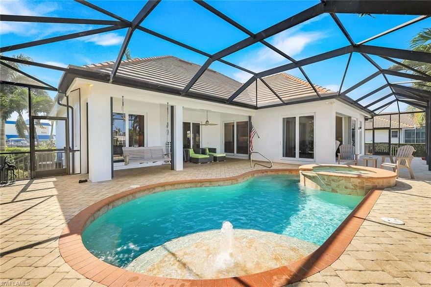 Where timeless design meets the art of coastal living. Just four houses from the Marco River and Factory Bay, this meticulously renovated coastal residence of 3 Bed | 2BA | 3042SF TTL reflects exceptional quality and refined style, capturing the spirit of island living where light, space, and water flow together effortlessly. Set on an oversized 100 x 110 homesite of .26 acres, the property, built by Arthur Rutenberg, welcomes you with a circular driveway framed by swaying palms and a distinctive double-door entry. Every architectural detail has been thoughtfully considered, from graceful arches and elegant coffered tray ceilings to the natural flow of its open living spaces. Inside, a refined coastal palette enhances the great room and chef's kitchen—complete with stainless appliances, a walk-in pantry, and generous island and peninsula seating designed for gathering, entertaining, and everyday comfort. The primary suite is a private retreat, with lanai access, dual walk-in closets, and a re-imagined spa-inspired bath with walk in shower, soaking tub, accented by designer tiling, lighting, and fixtures. While 2 more split bedrooms with a 2nd renewed designer bath, and a flex space with laundry, sink and built-in desk, may easily become the 4th bedroom or study. Step outside to the fully screened lanai and experience a private resort setting with sparkling pool and integrated spa with open and covered lounging, dining and living areas surrounded by lush tropical landscaping. A U-shaped dock with slip and 14,000-lb lift offers quick, water-direct access to the Gulf—perfect for sunset cruises or a spontaneous day on the water. (Seawall 2009). Impact glass, electric storm shutters, new A/C and fencing (2024), a grand circular drive, and deep two garages for 3+ cars with built-ins complete the picture of luxury, comfort, and confidence. Live where every detail reflects thoughtful design, enduring quality, and the effortless elegance of Marco Island's Florida lifestyle on the water.