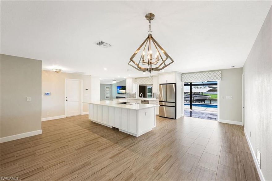 Welcome to your dream Gulf-Access pool home in SE Cape Coral! This beautifully remodeled home offers the perfect fusion of modern elegance and coastal charm. Featuring a newly renovated kitchen with high-end appliances, abundant soft-close cabinetry, an oversized 13' x 4' kitchen island with Quartz countertops and bar seating, and a large pass-through window that opens to the lanai and pool. The spacious living room showcases a Napoleon Fireplace and a 75-inch Samsung TV for ultimate relaxation and entertainment, plus built-in cabinets for additional storage. Each bathroom is designed with new vanities, quartz countertops, decorative shower tiles, and glass enclosures. The outdoor living area is an entertainer’s paradise, complete with a fully-equipped outdoor kitchen featuring a Twin Eagle grill and cooktop, a pavered lanai, new pool enclosure, and lanai screens. Boaters will love the new composite dock with a 13k lb Neptune boat lift and canopy, along with a Tiki Hut to watch breathtaking sunsets over the intersecting canal. Additional home features include woodgrain tile flooring throughout, a water filtration system, reverse osmosis for drinking water, impact windows and doors, Kevlar hurricane shutters, new lighting, ceiling fans, Plantation shutters, LCEC surge protection, and Solar Panels with an Enphase system PAID OFF (reducing your electric bill by 40%). For a full list of upgrades, please refer to the attached Features List.  Don’t miss your opportunity to experience the Florida lifestyle—schedule your private tour today!